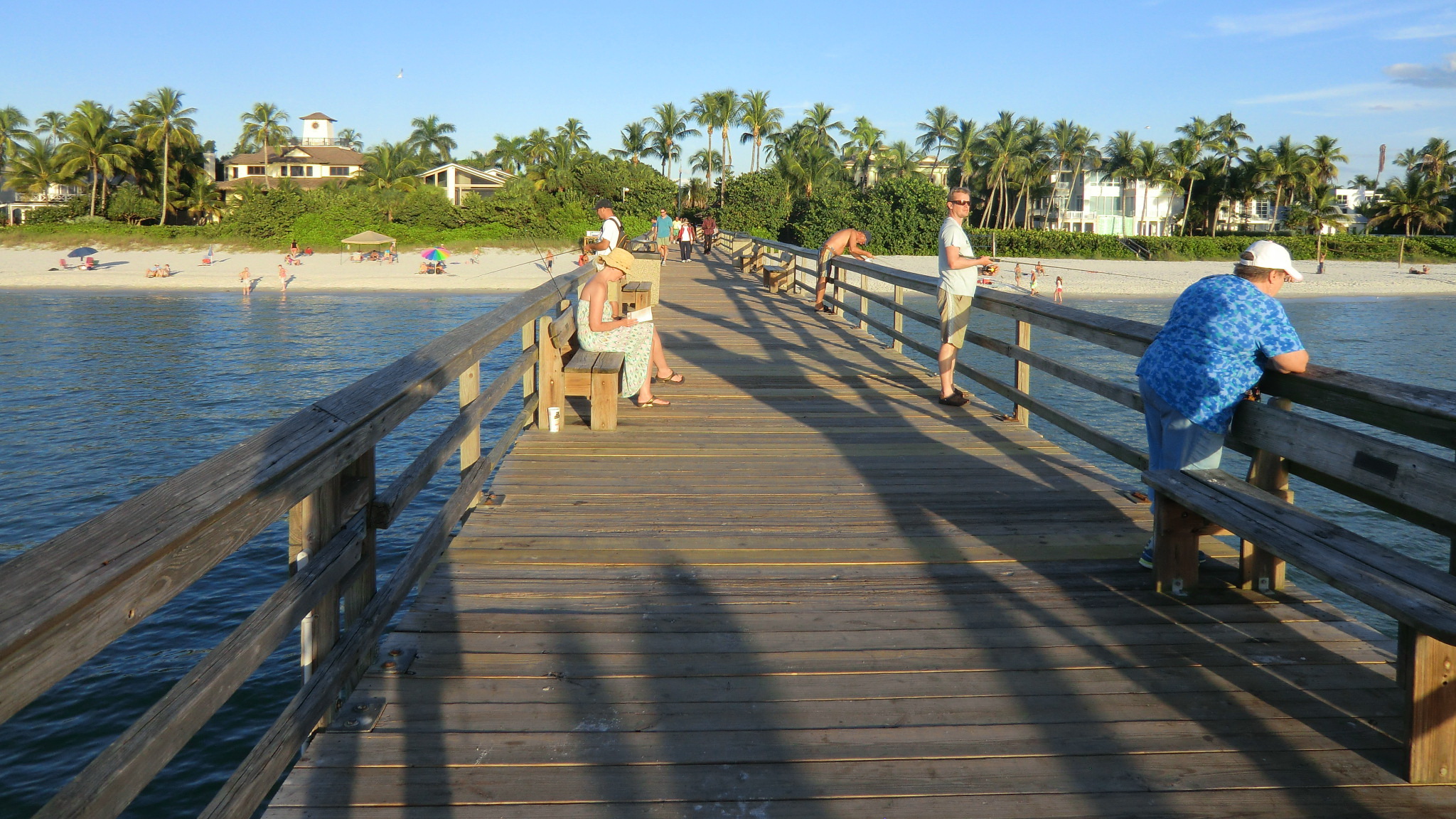 Naples historic wooden fishing pier extending into the Gulf of Mexico at sunset with anglers