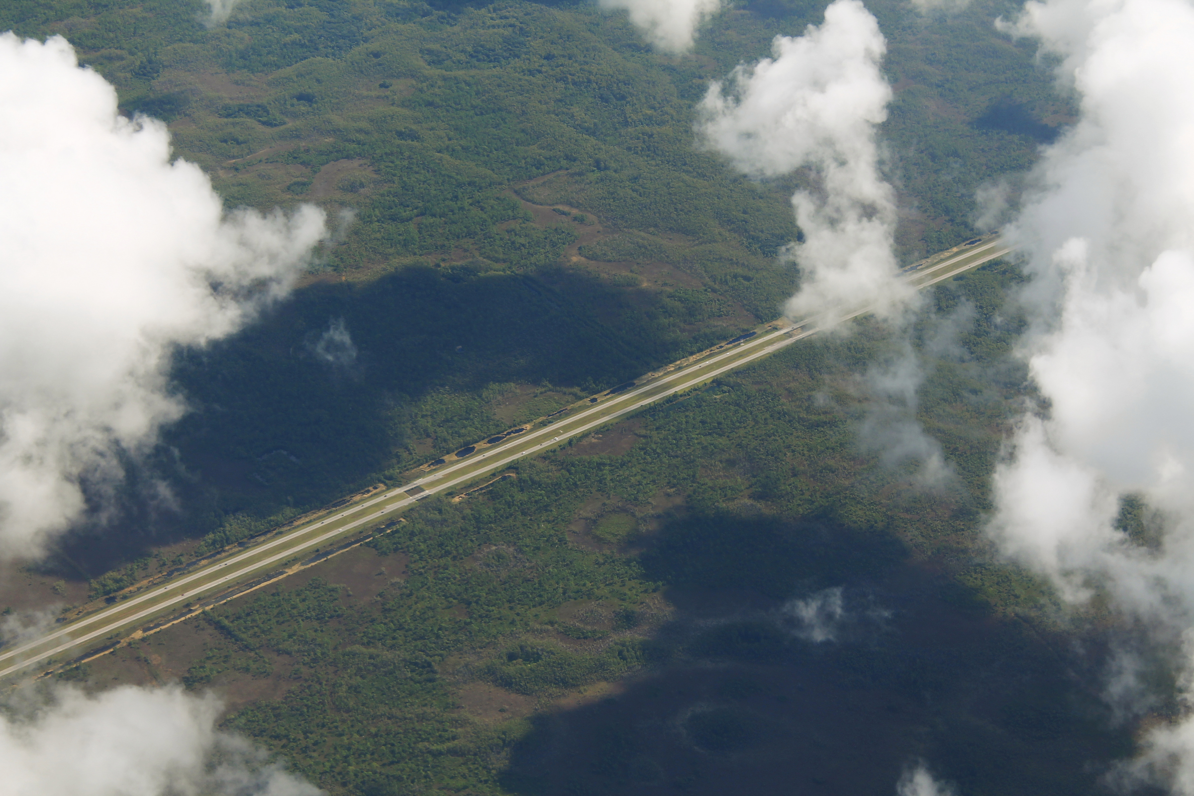 Aerial view of a Florida toll-road corridor cutting across flat green wetlands
