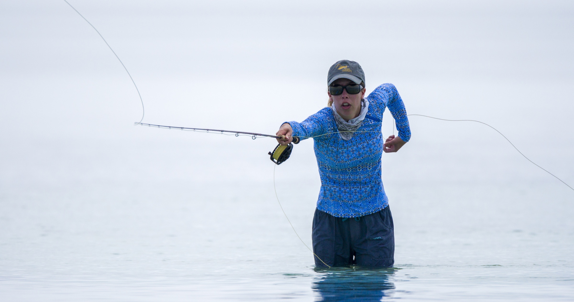 Un pescador se para en las aguas poco profundas y soleadas del Santuario Marino Nacional de los Florida Keys, lanzando una caña de mosca sobre los flats cristalinos