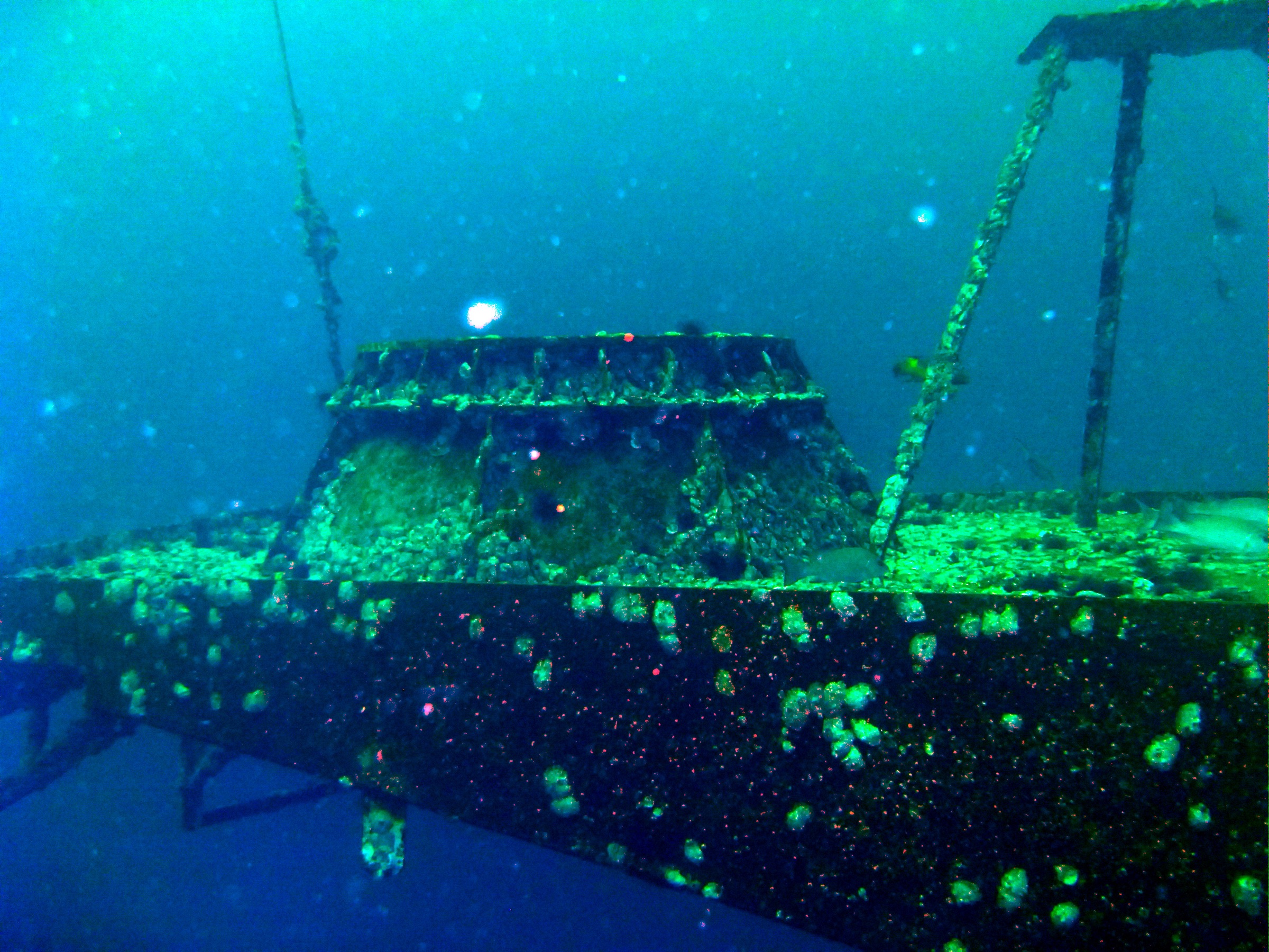 Scuba diver near the island tower of the sunken USS Oriskany aircraft carrier