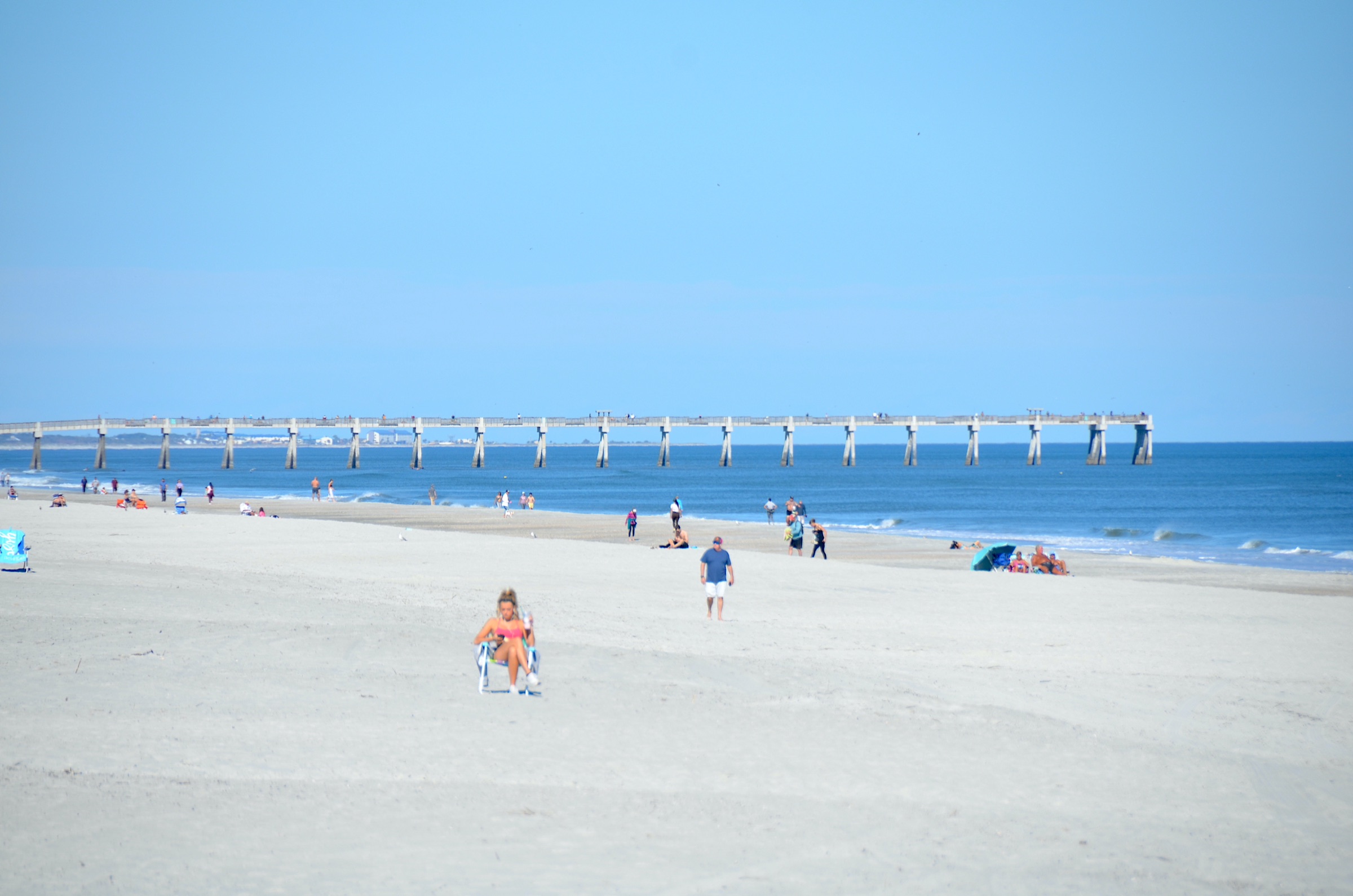 Fishing pier extending into the Atlantic Ocean at Jacksonville Beach, Florida, under clear skies
